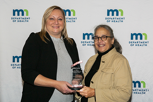 Lori Swansonreceiving award from Assistant Commissioner Mary Manning.