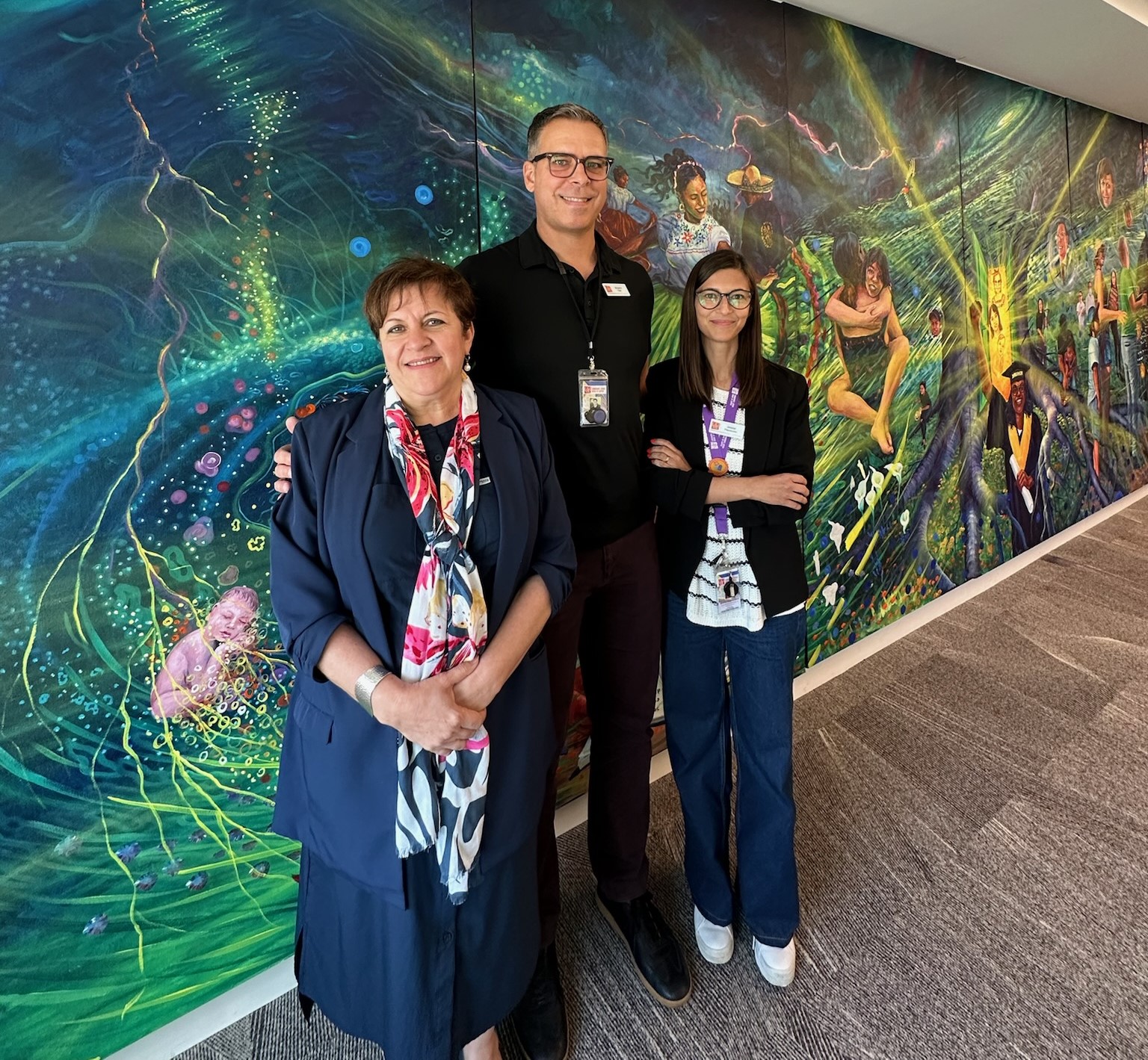 Photo of the CLUES team, Ruby, Ben, and Jessica posing in front of a color wall.