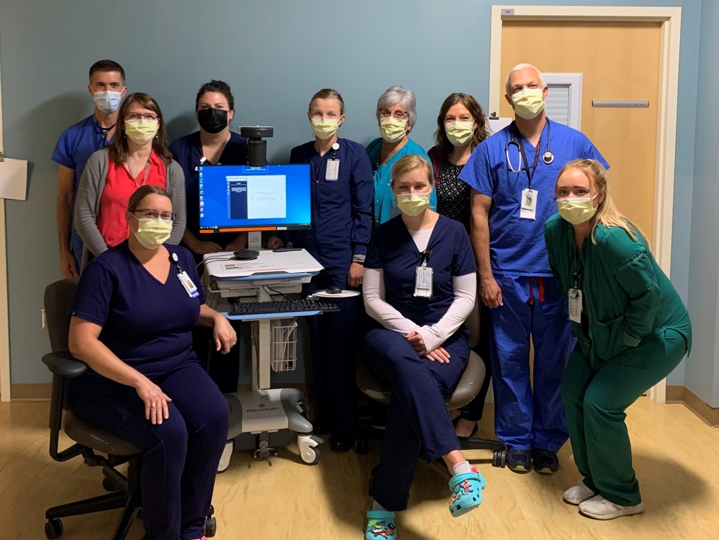 healthcare workers gathered around a computer