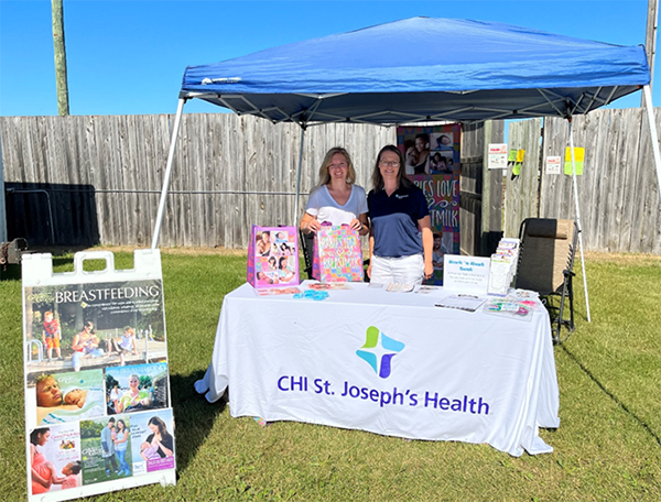 WIC staff under tent with promotional material.