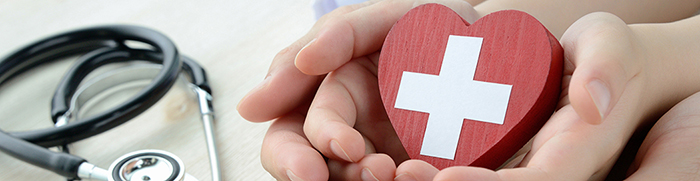 Large hands holding small hands with a heart and stethoscope