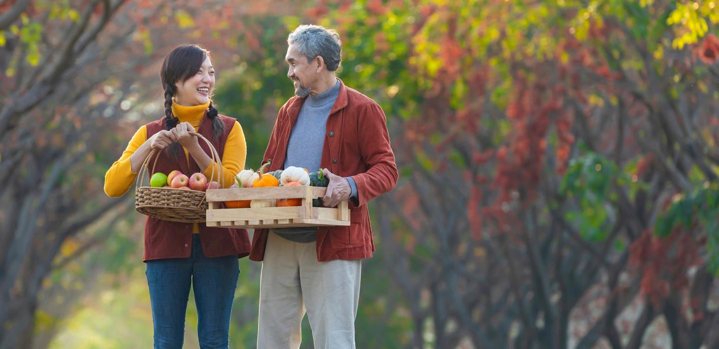 Couple walking with baskets of fruits and vegetables